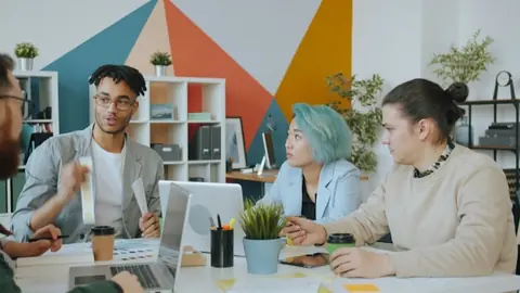 Design team collaborating around a table in a colourful studio